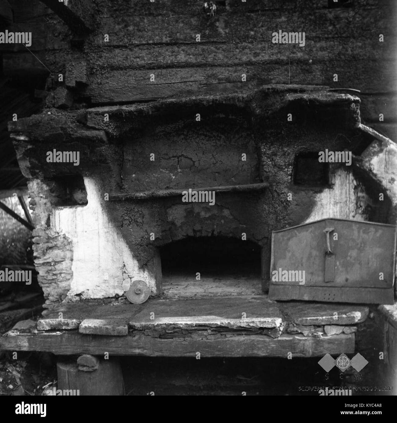 Foto aus dem Jahr 1963 von einem traditionellen Herd („ognjišče“) in einem teilweise verfallenen Haus am Standort Grobelnik im Dorf Hudinja, Slowenien, das den häuslichen Niedergang und die ländliche Struktur in einem Zustand Mitte des 20. Jahrhunderts zeigt. Stockfoto
