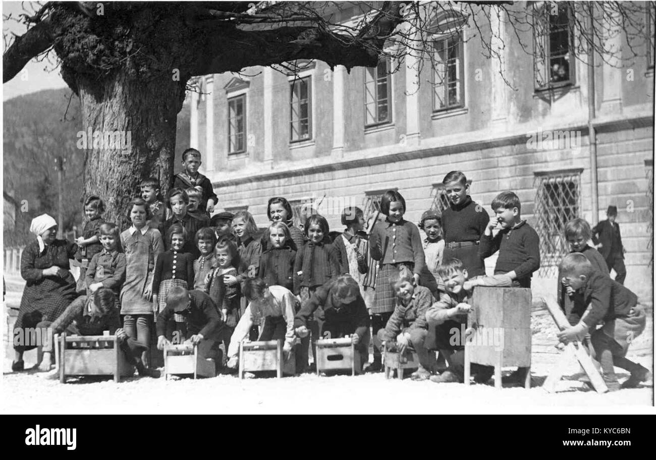 Ein slowenisches Foto aus dem Jahr 1940, auf dem Kinder bei Karfreitagsfeiern hölzerne Rasseln verwenden, eine traditionelle christliche Praxis, die Kirchenglocken ersetzt und die Hingabe und Teilnahme an der Gemeinschaft symbolisiert. Stockfoto