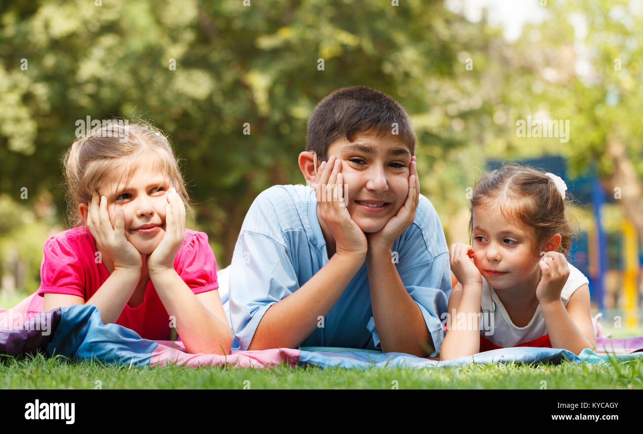 Gruppe von drei glückliche Kinder, die auf dem Gras Stockfoto