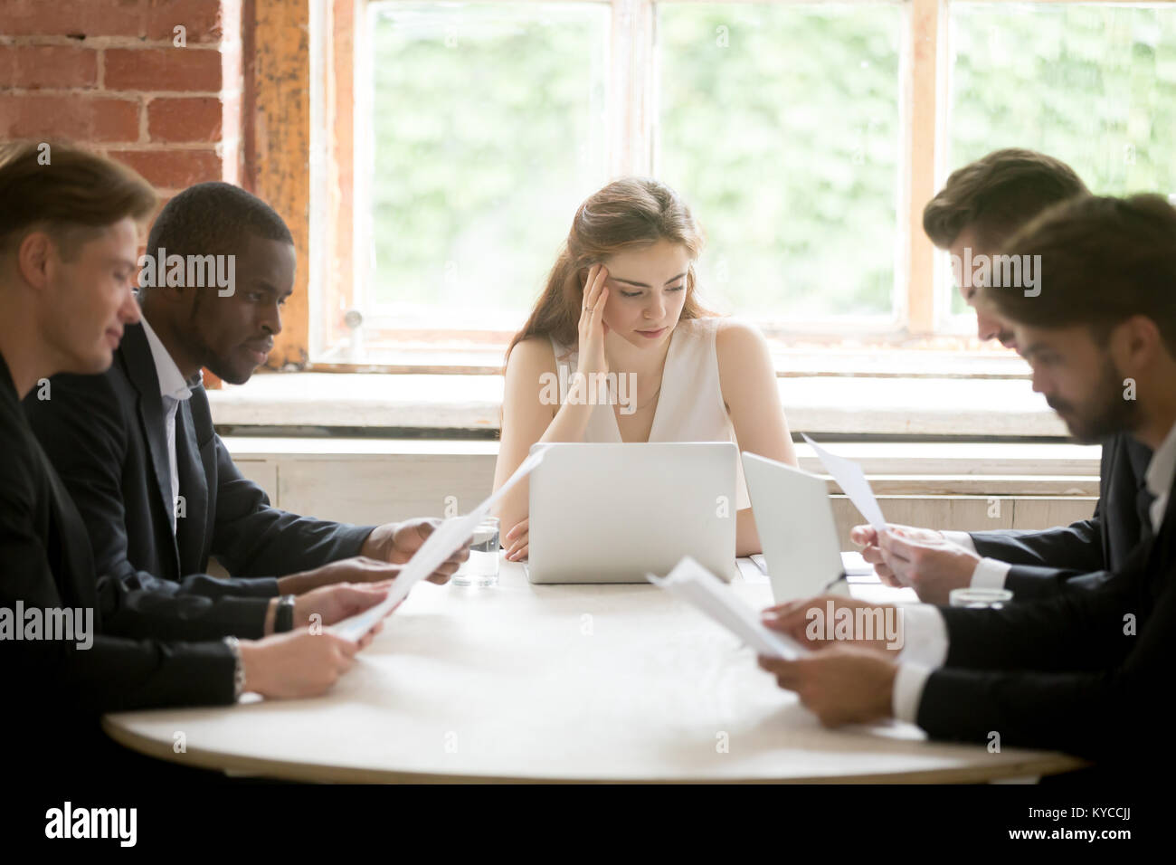 Ernsthafte multirassischen Geschäftsleute halten Dokumente bei Treffen mit Geschäftsfrau, männliche diverse Unternehmer unter Berücksichtigung neuer Vertrag mit weiblichen Partn Stockfoto