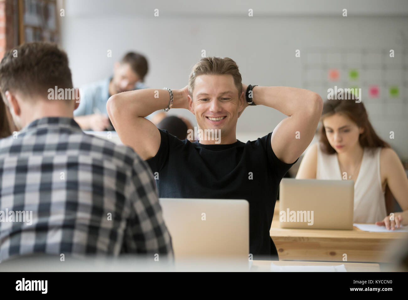 Unternehmer fühlt sich zufrieden lächelnd auf Laptop Bildschirm in Coworking Space, Office Mitarbeiter gerade online Projekt durch gutes Ergebnis motiviert abgeschlossen Stockfoto