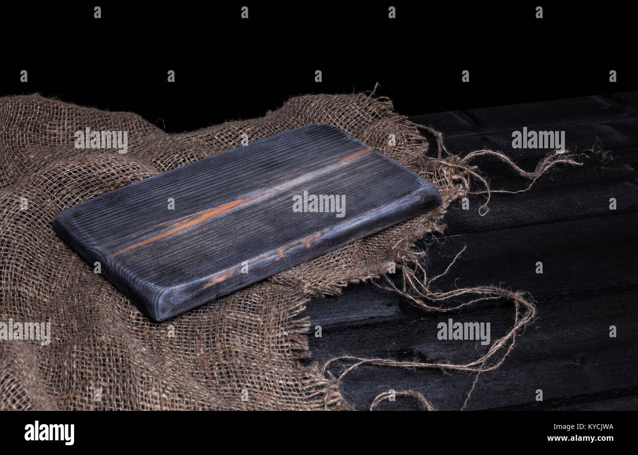 Dunklen Holztisch für Produkt-, alten, schwarzen Holz- perspektive Interieur mit alten Schneidebrett Stockfoto