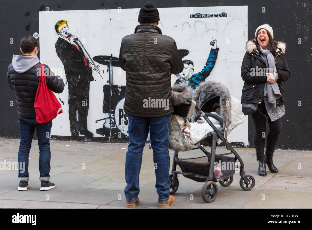 Shoreditch, London, 14. Jan 2018. Londonern und Touristen Reagieren und Interagieren mit einem neuen street art Stück für Loretto, Darstellung von US-Präsident Donald Trump als Leadsänger der Band "Psychos", mit Wladimir Putin am Schlagzeug und Nordkoreas Kim Jong-un an der Gitarre. Die Arbeit ist von der Londoner Künstler Loretto, deren Stücke mit sozialpolitischen Kontext, in banksy-esque Stil, über London im letzten Jahr erschienen sind. Credit: Imageplotter Nachrichten und Sport/Alamy leben Nachrichten Stockfoto