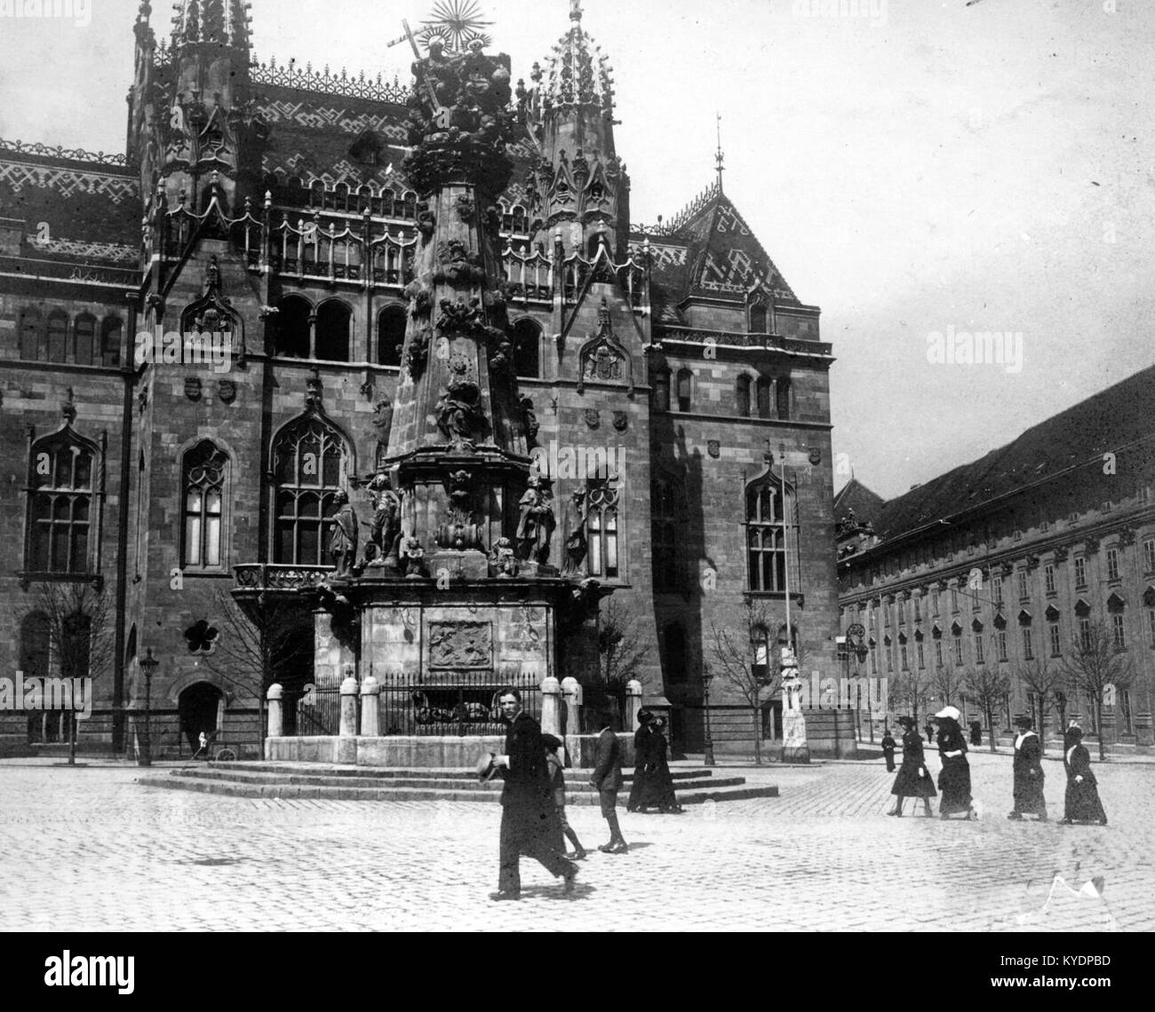 Ein Foto des Szentháromság-Platzes in Budapest mit der Heiligen Dreifaltigkeitsstatue und dem Gebäude des Finanzministeriums im Hintergrund, das historische Barockarchitektur und urbanes Erbe hervorhebt. Stockfoto
