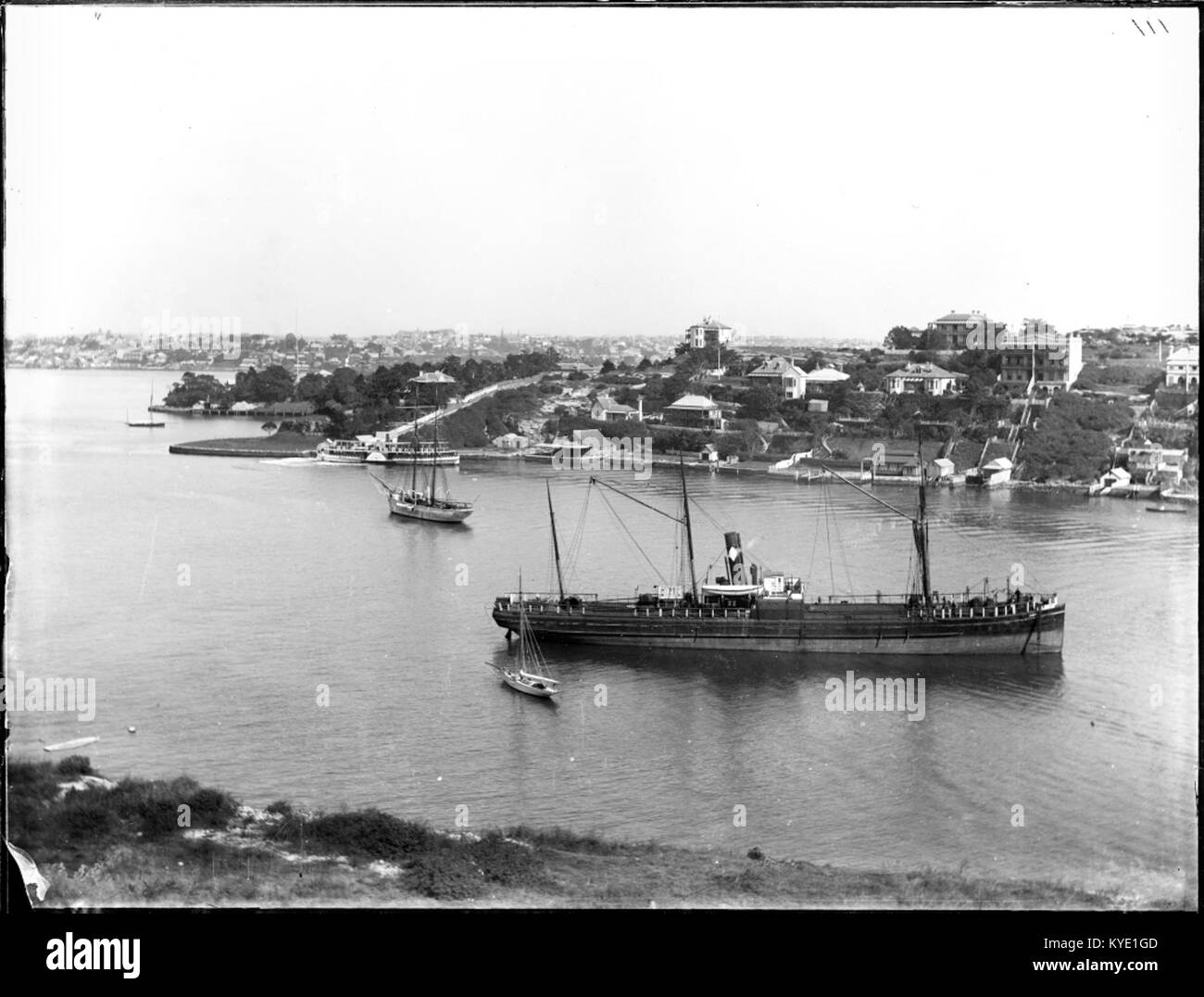 Eine Dreimastfähre wird an einem Kai vor Anker gestellt, mit Takelage, Rumpf und Dock, die typisch für die Epoche sind. Stockfoto