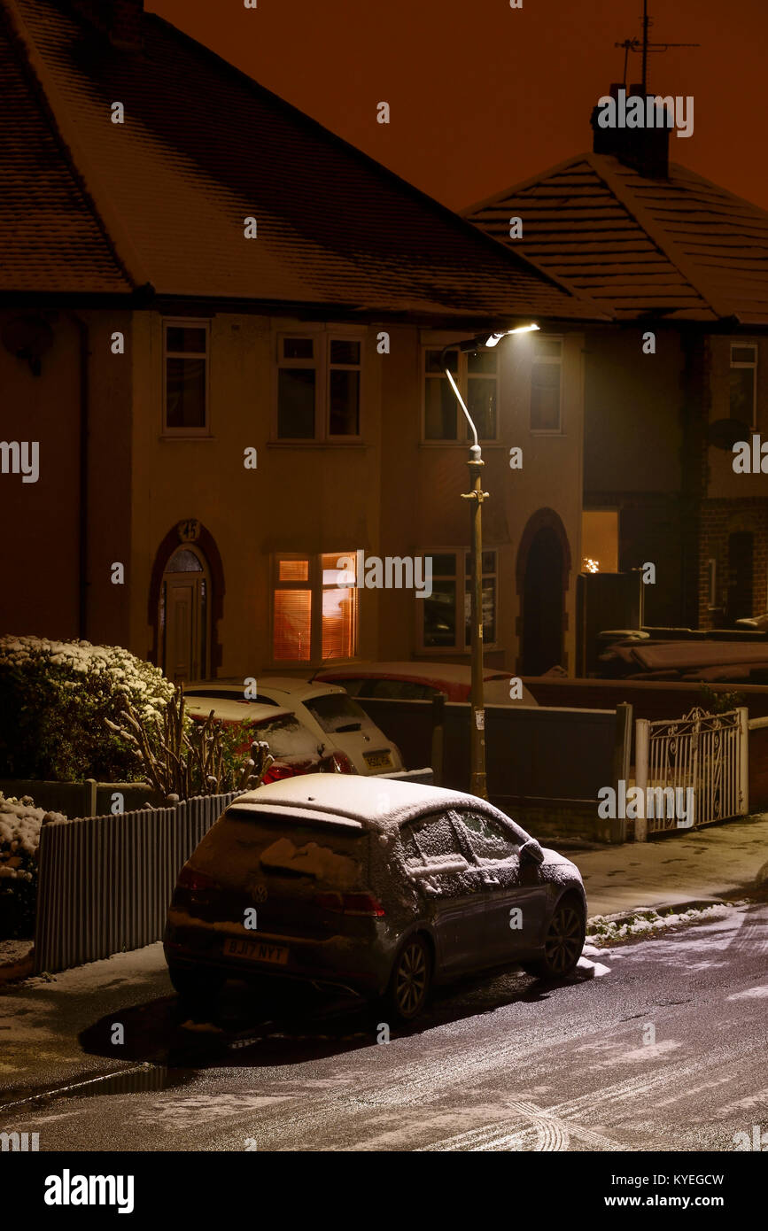 Ein Auto unter einer Straßenlaterne in eisigen Bedingungen auf einer Vorstadtstraße in Großbritannien geparkt Stockfoto