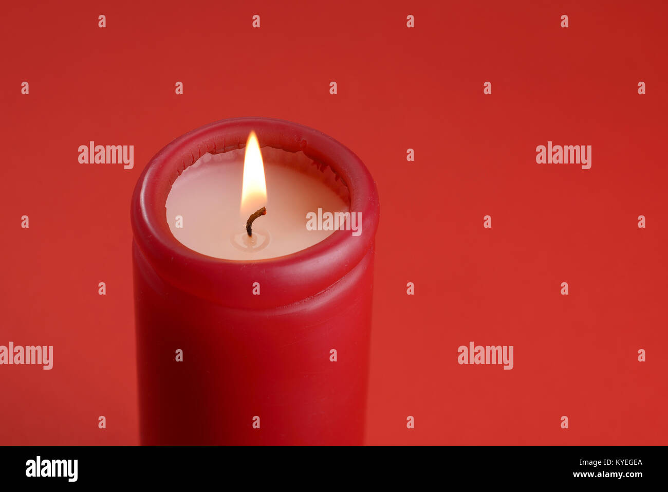 Brennende Flamme auf eine rote Kerze Stockfoto