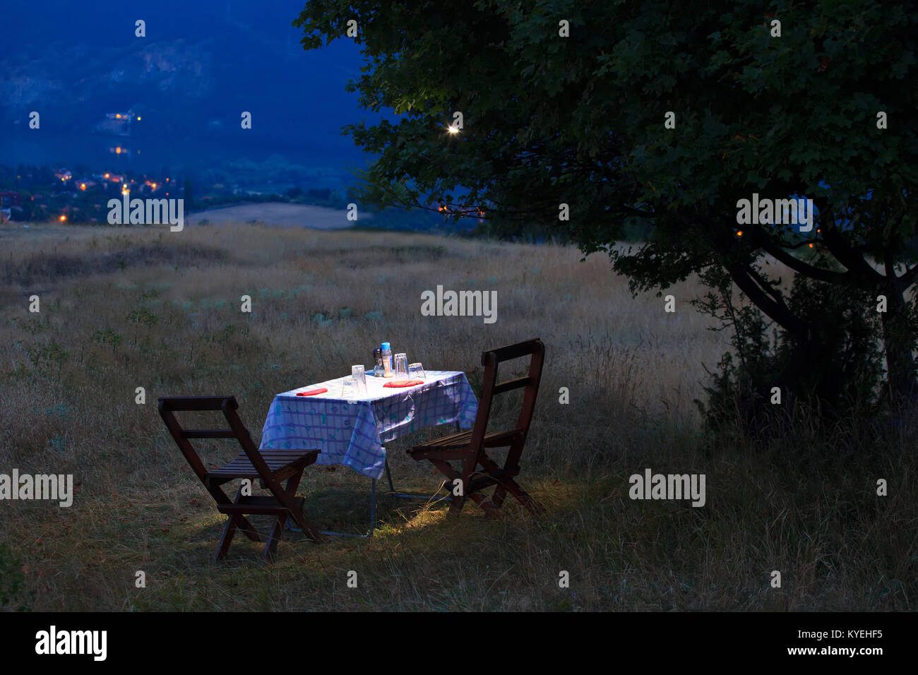 romantischen Tisch für zwei Personen in der Vollmondnacht, Felder in der Natur in der Nähe von hohen Bergstadt Stockfoto