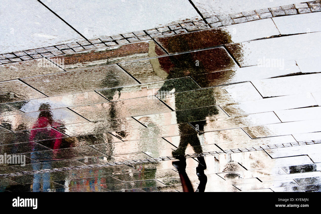 Regen Reflexion silhouette Schatten von Menschen auf nassen Straßen der Stadt an einem regnerischen Tag Stockfoto