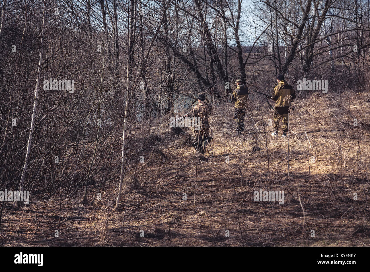 Jagdszene mit einer Gruppe von Jägern in der Tarnung stehlen in trockenen Wald während der Jagdsaison Stockfoto