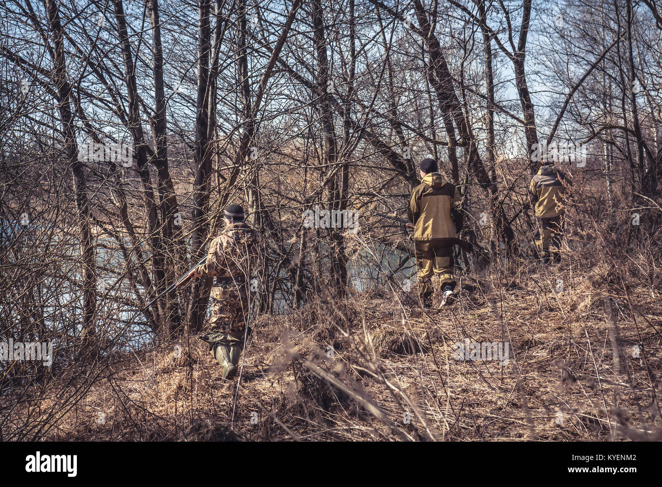 Gruppe von Jägern in der Tarnung Diebstahl im Frühjahr Wald während der Jagdsaison Stockfoto