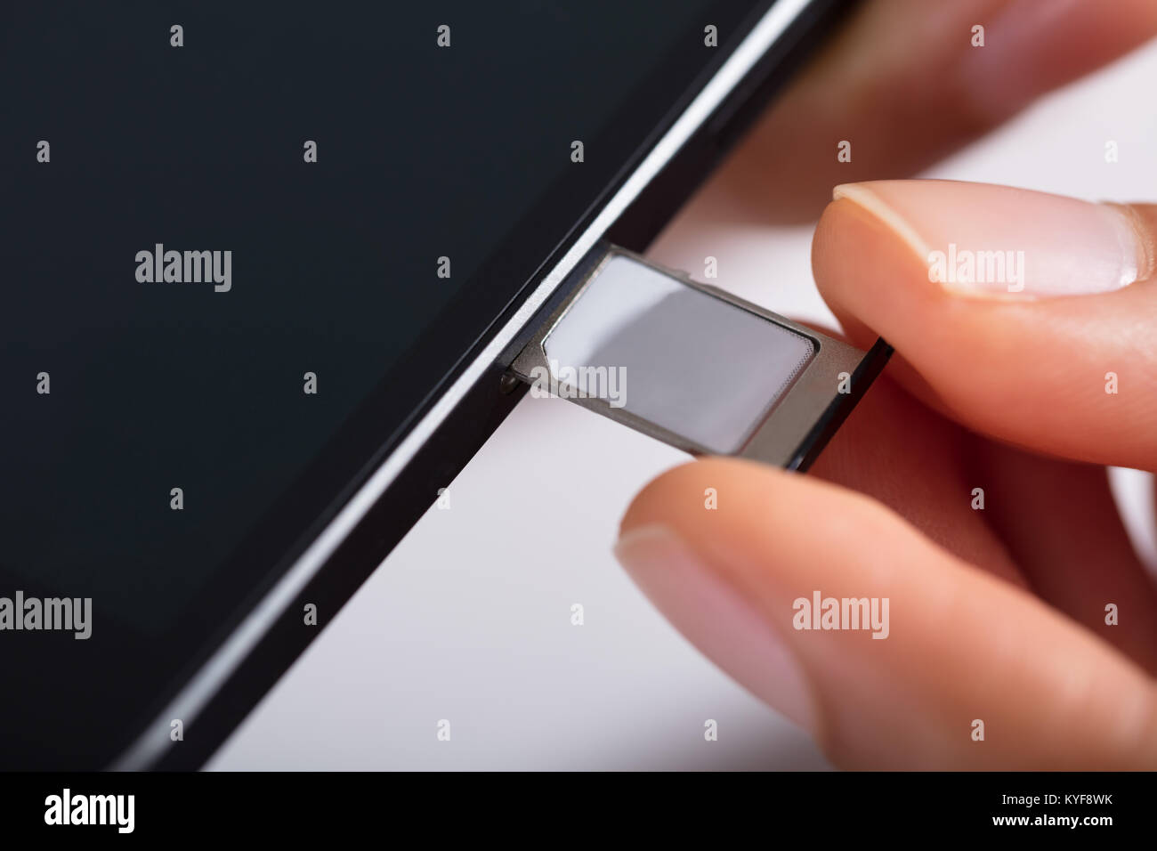 In der Nähe der Person Hand einfügen Micro-SIM-Karte im Handy Stockfoto