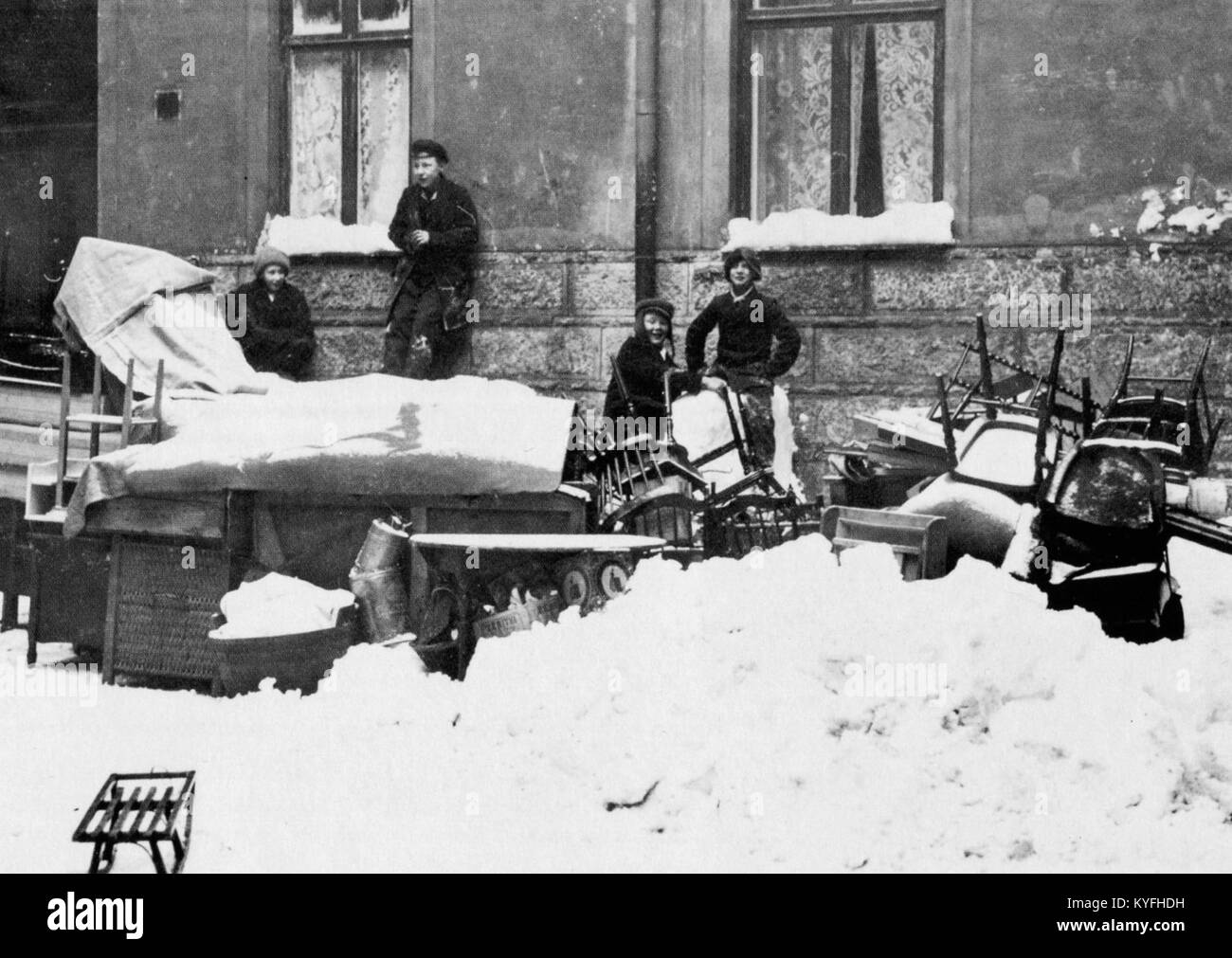 Ein Schwarzweißfoto aus den 1910er Jahren, das eine Straßenszene in Stockholm, Schweden, darstellt. Das Bild zeigt einen Pferdewagen mit einem großen Holzfass, der geladen oder entladen wird, möglicherweise während der Räumung. Die Umgebung wirkt städtisch, mit Gebäuden und Kopfsteinpflasterstraßen, die typisch für Stockholm aus dem frühen 20. Jahrhundert sind. Das Foto fängt einen Moment des historischen Alltags ein und spiegelt die Architektur der Stadt und die sozialen Bedingungen der Zeit wider. Stockfoto