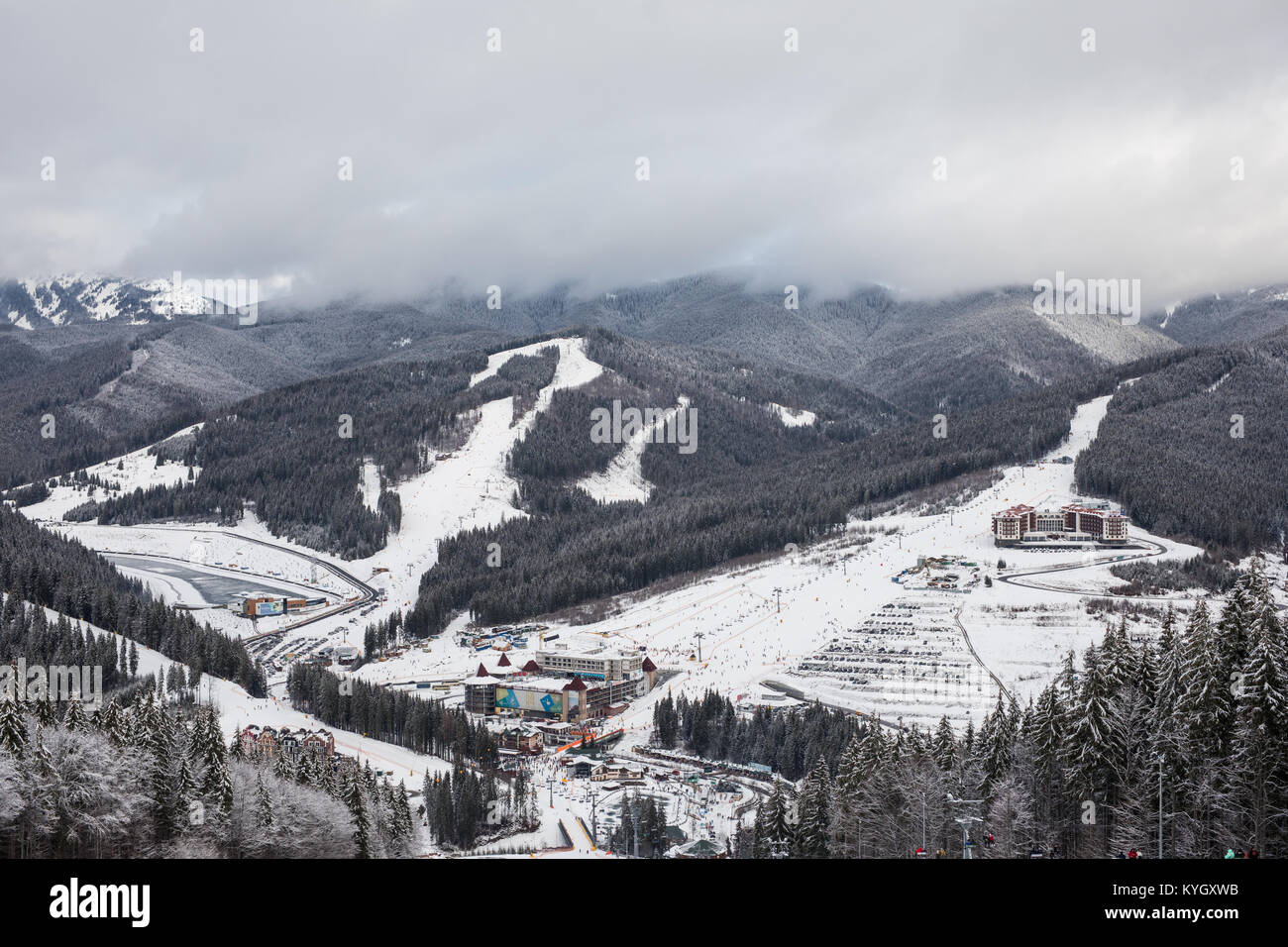 Panorama der präparierten Piste unter Fichtenwald auf einem Hintergrund von Bergketten und Sky auf Ski Resort in Karpaten Stockfoto