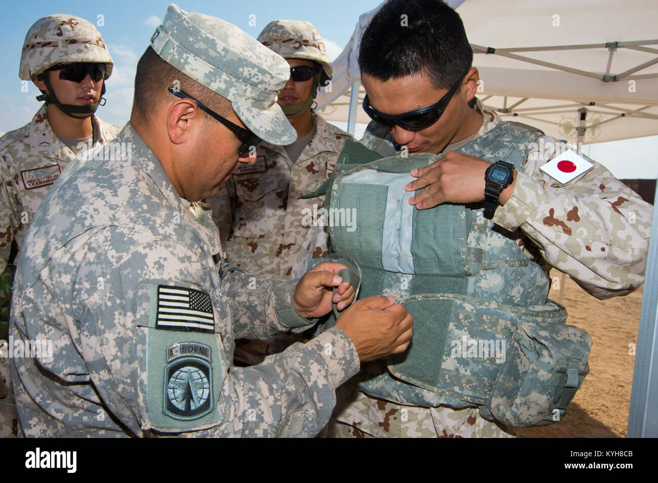 US Army 1st Lt. Oscar Ortiz, Kentucky Army National Guard 2. Bataillon 138. Field Artillery Regiment Executive Officer sichert eine taktische Weste auf japanischen Boden Self Defense Kräfte SGT Kawamoto Yuji, Mitglied der Sicherheitskräfte während der Counter improvisierten Sprengkörpern und explosive Ordnance Entsorgung Ausbildung auf Camp Lemonier, Dschibuti, 30. November 2012. Dieses Ereignis half Förderung gegenseitigen Verständnisses zwischen amerikanischen und japanischen Streitkräften und verbessert ihre Fähigkeit zur Durchführung von integrierten Einsätze zur Unterstützung ihrer gegenseitigen Interessen und kombiniert Joint Task Force-Horn Stockfoto