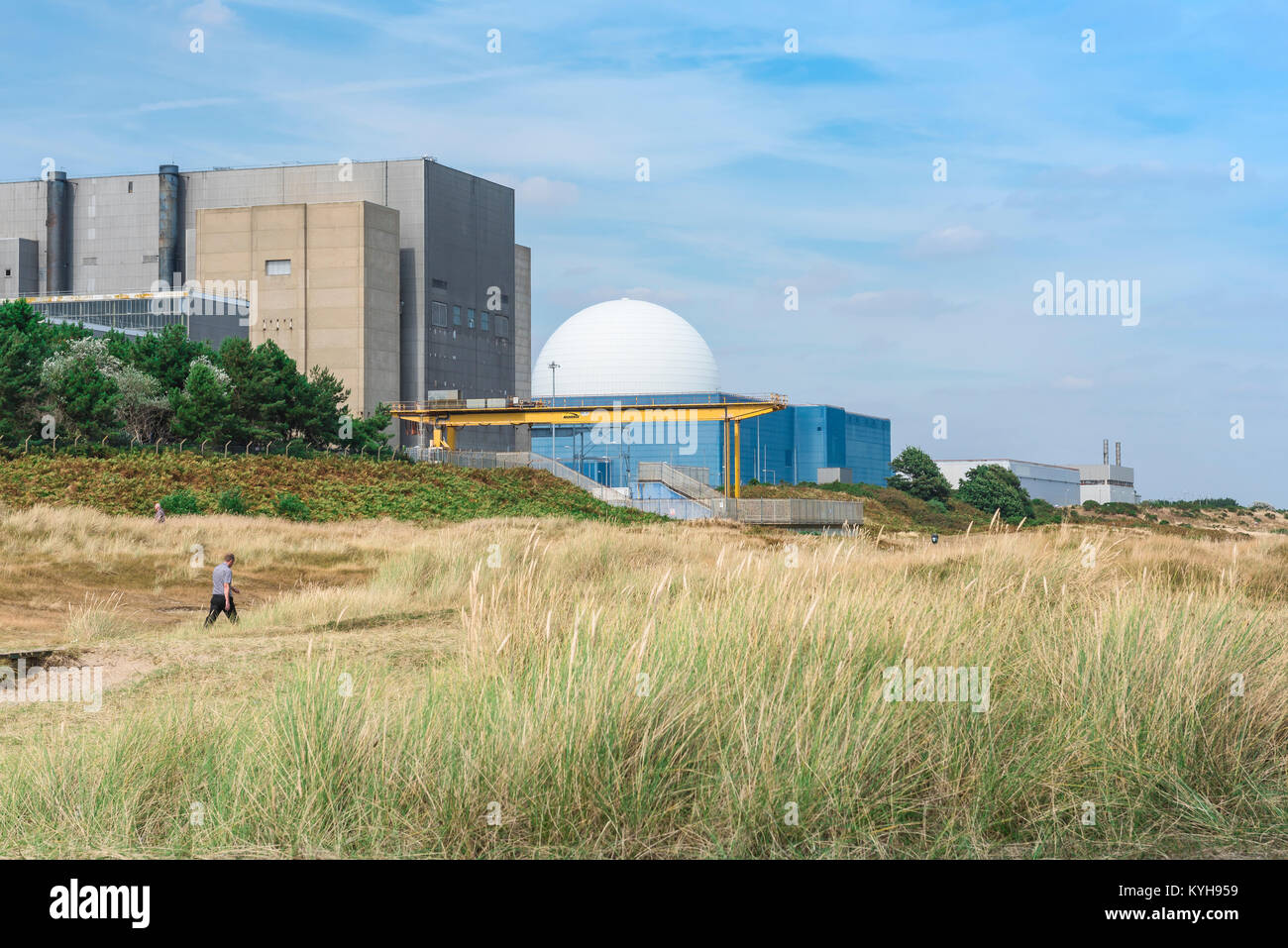 Sizewell Suffolk UK, Blick auf einen Mann, der durch Sanddünen in der Nähe des Kernkraftwerks Sizewell B an der Suffolk Küste, England, UK, läuft. Stockfoto