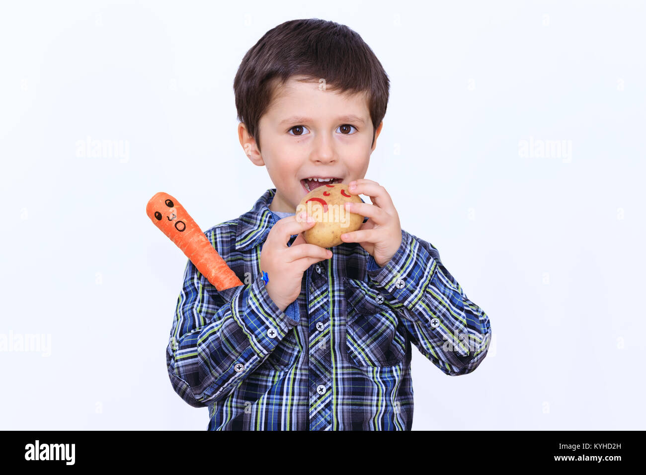 Die intelligente Kind liebt frische Kartoffeln zu essen. Der Junge versucht, seine Gesprächspartner zu essen. Stockfoto