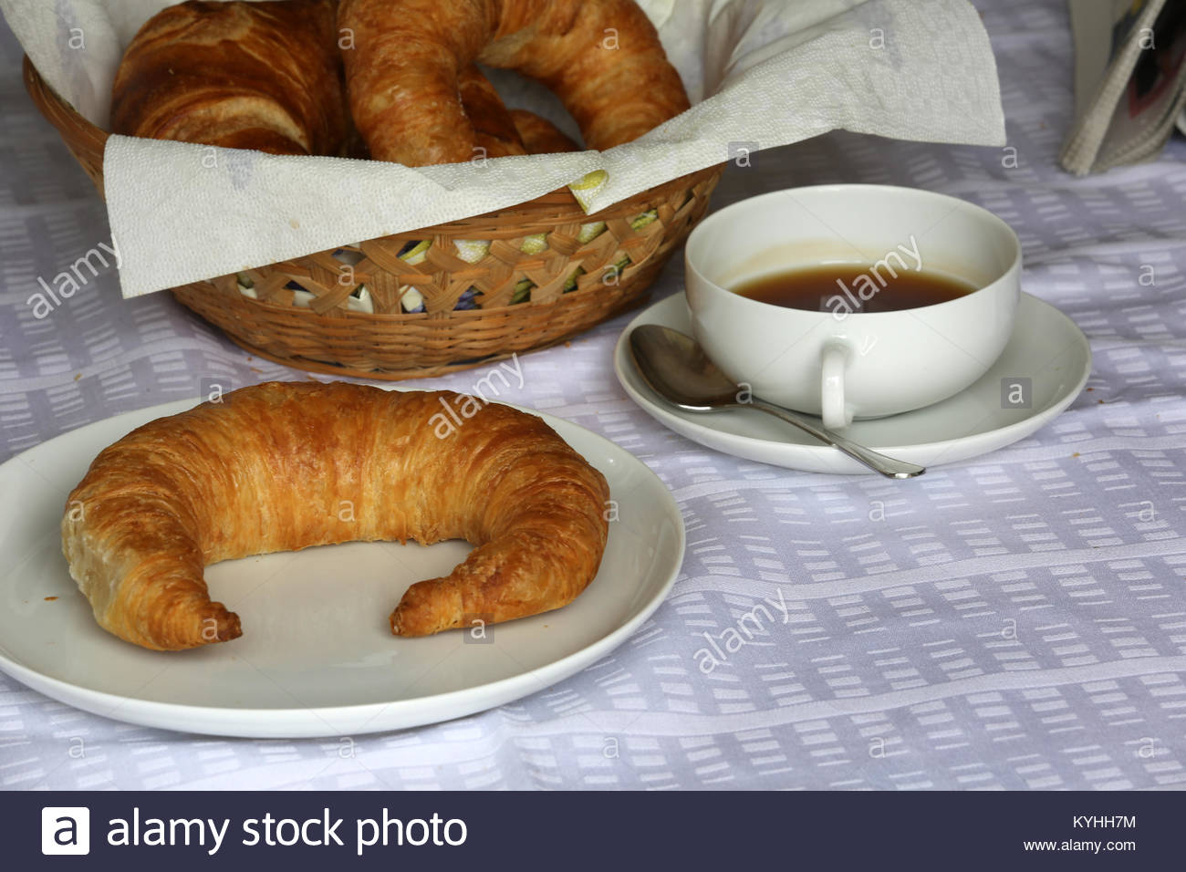 Eine flockige Bamberg Croissant auf einem weißen Teller neben einer Tasse Kaffee in der deutschen Küche zum Frühstück Stockfoto