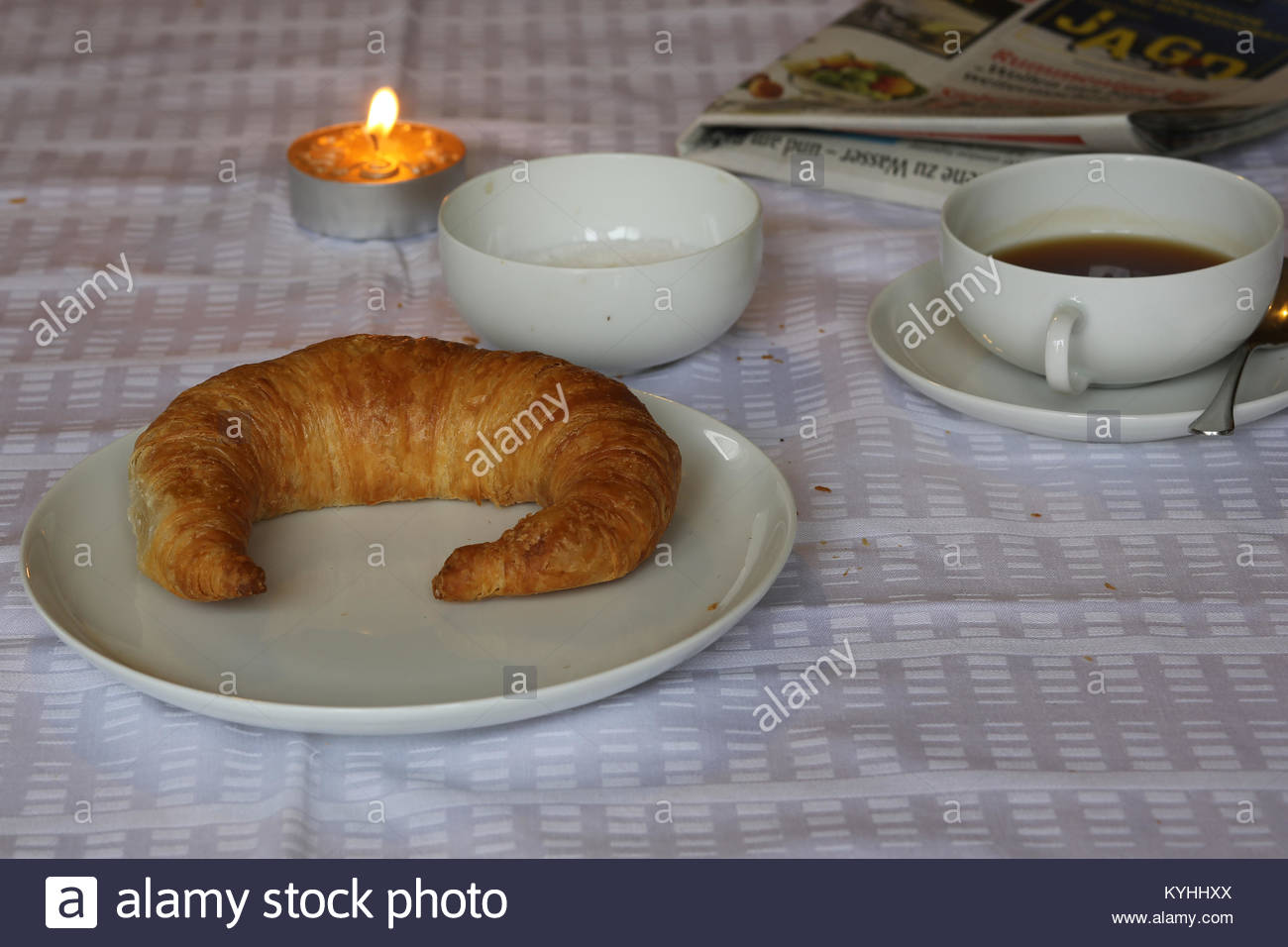 Eine flockige Bamberg Croissant auf einem weißen Teller neben einer Tasse Kaffee in der deutschen Küche zum Frühstück Stockfoto