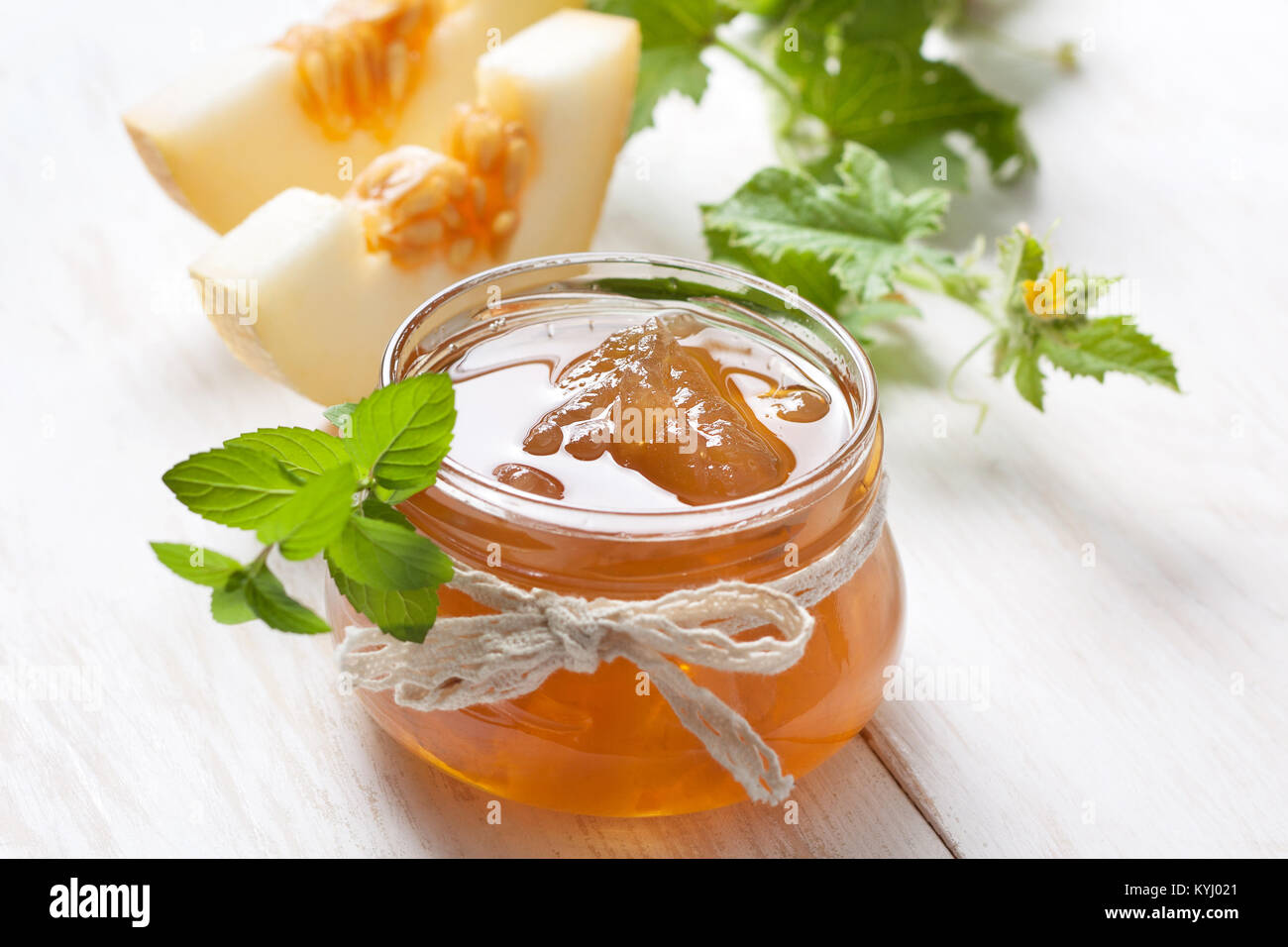 Stau Melone in einem Glas, Scheiben der Melone auf einem weißen Holz- Hintergrund Stockfoto