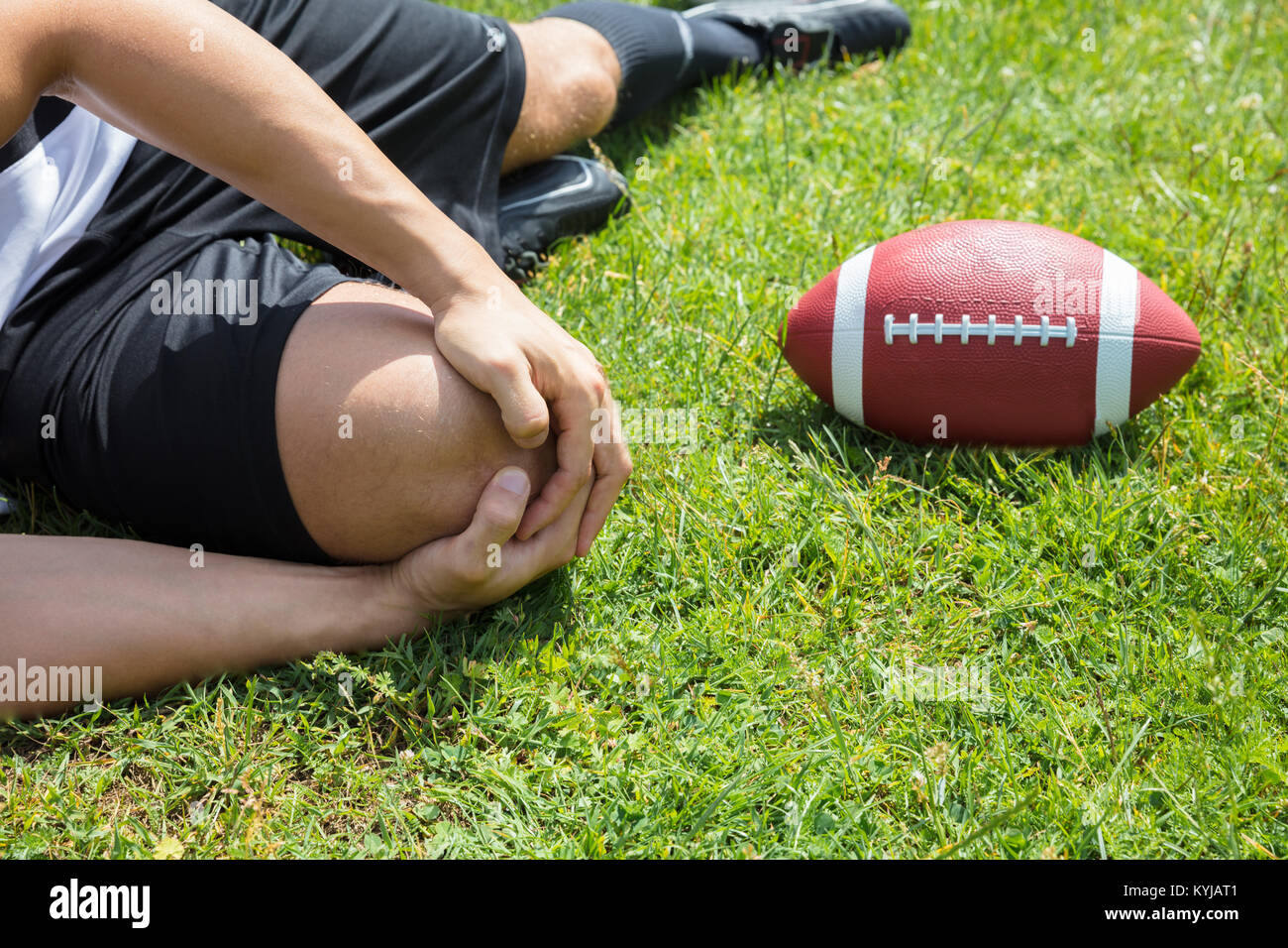 Nahaufnahme der männlichen Rugbyspieler Leiden Knieverletzung liegen auf Feld Stockfoto