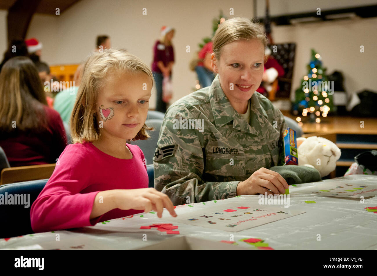 Staff Sgt. Melissa Longhofer, eine geordnete Zimmer Administrator mit der 123 Aircraft Maintenance Squadron, spielt Bingo mit ihrer Tochter während der Familie Urlaub Party's der 123 Airlift Wing an der Kentucky Air National Guard Base in Louisville, Ky., Dez. 2, 2012. Die jährliche Veranstaltung bietet auch Snacks und Preise für die mehr als 85 Kinder, die teilgenommen haben. (Kentucky Air National Guard Foto: Staff Sgt. Maxwell Rechel) Stockfoto