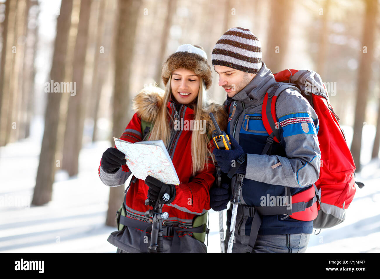 Wanderer auf der Suche nach Weg auf der Karte in Holz im Winter Stockfoto