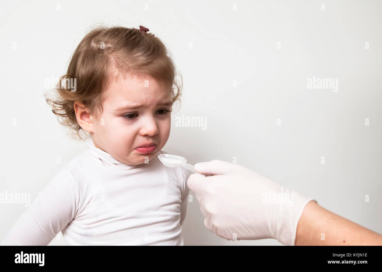 Kleines Mädchen Einnahme von Medizin mit Löffel Stockfoto