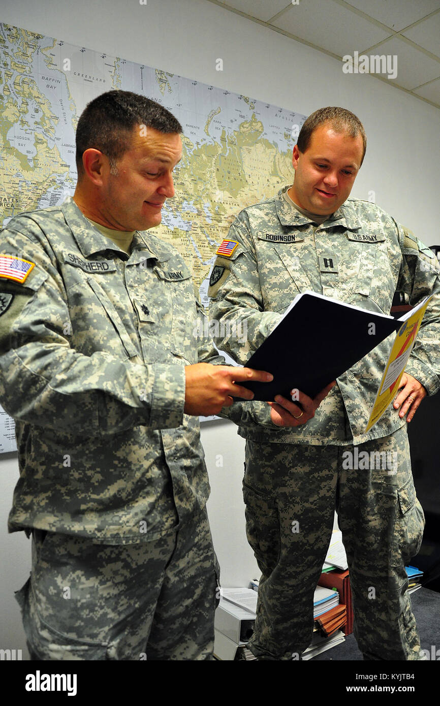 Oberstleutnant Jason Shepherd und Kapitän Spencer Robinson ein juristischer Fall Datei in Frankfort, Ky., Aug 19, 2014 diskutieren. Die Mitglieder der Kentucky Guard Personal Judge Advocate General's Unterstützung im Umgang mit einer Vielzahl von rechtlichen Fällen auf einer täglichen Basis. (U.S. Army National Guard Foto: Staff Sgt. Scott Raymond) Stockfoto