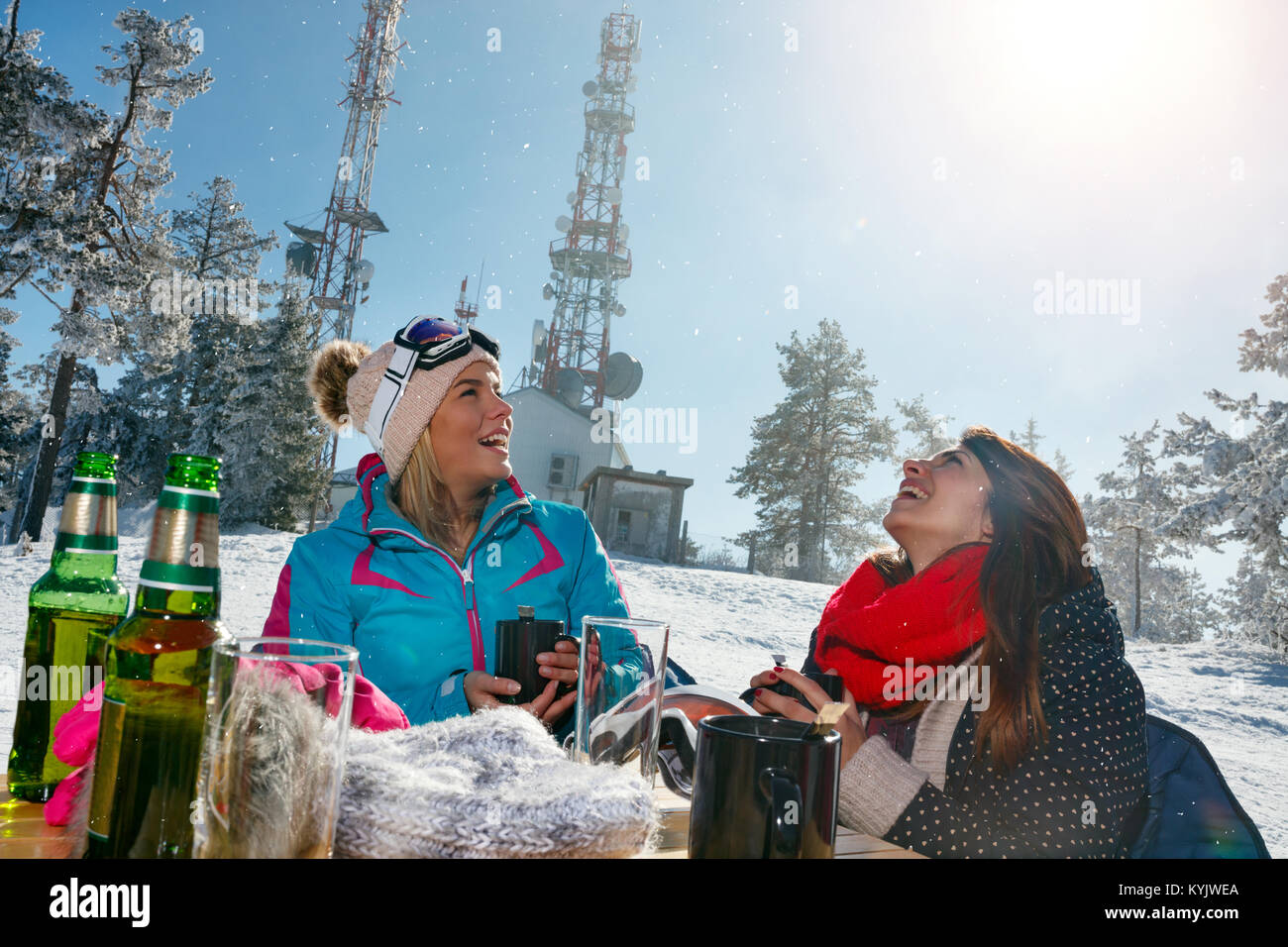 Gerne weibliche Freunde zusammen genießen Sie heiße Getränke im Café zu Ski Resort Stockfoto