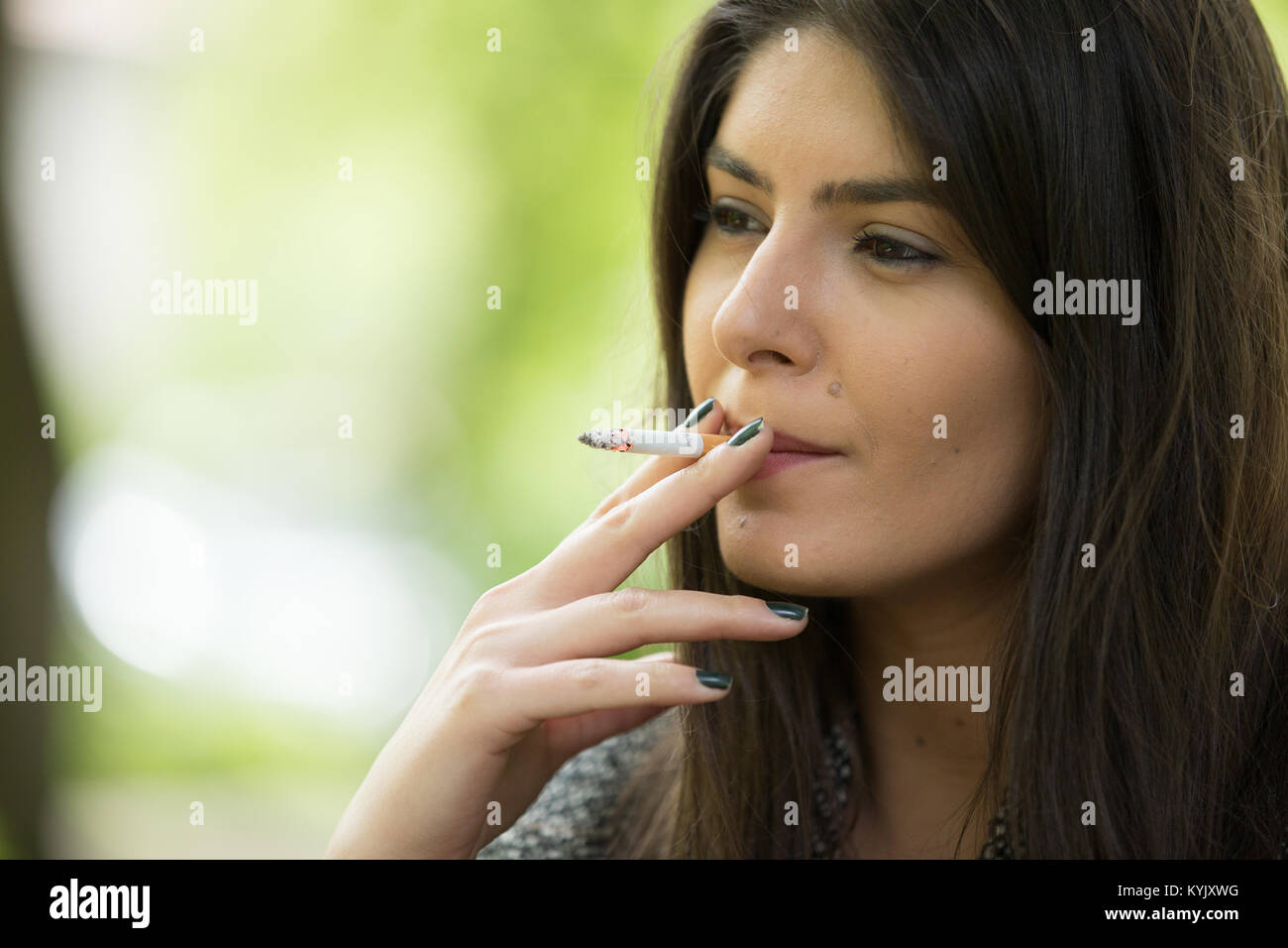Frau raucht im Park Stockfoto