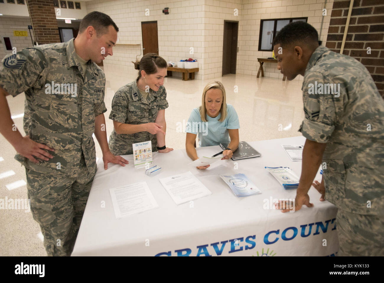 Us-Luftwaffe Kapitän Lauren Lwanga, ein Offizier des öffentlichen Gesundheitswesens von 123 Medical Group die Kentucky der Air National Guard, und Tech. Sgt. Wes Suche (links) und Flieger 1. Klasse Gregor Mitchell, öffentliche Gesundheit Techniker aus der 123 medizinische Gruppe, sprechen mit Riley Billett, Graves County Public Health Department Koordinator des Programms, auf Gräber County High School in Mayfield, Ky., 20. Juli 2016, während der Bluegrass Medical innovative Readiness Training. Die Kentucky Air National Guard, der U.S. Navy Reserve und andere militärische Einheiten teaming mit dem Delta regionale Behörde zu medizinischen und denta bieten Stockfoto