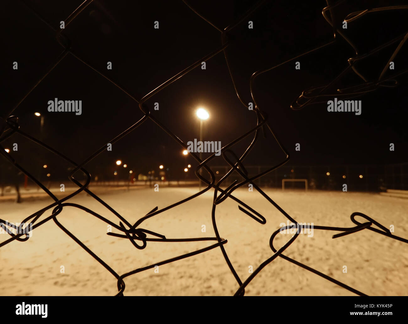 Ein Blick durch Maschendrahtzaun bei Nacht Stockfoto