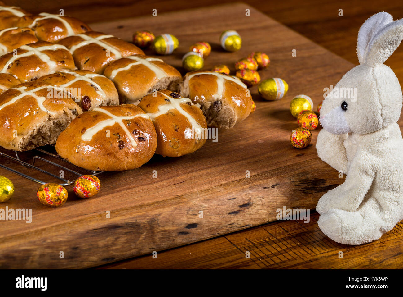 Frisch gebackene Hot Cross Buns mit Plüsch Spielzeug Hasen und Ostereier Stockfoto