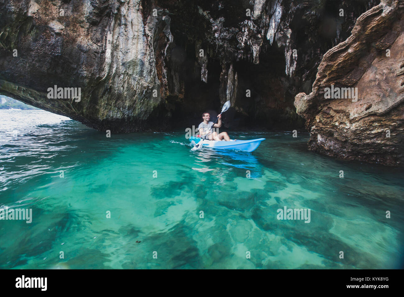 Kayaker Paddeln in kristallklarem Wasser in der Nähe der Höhle auf Railay Beach in Krabi, touristische Reisen auf Kajak in Thailand, verschwommene Bewegung Stockfoto