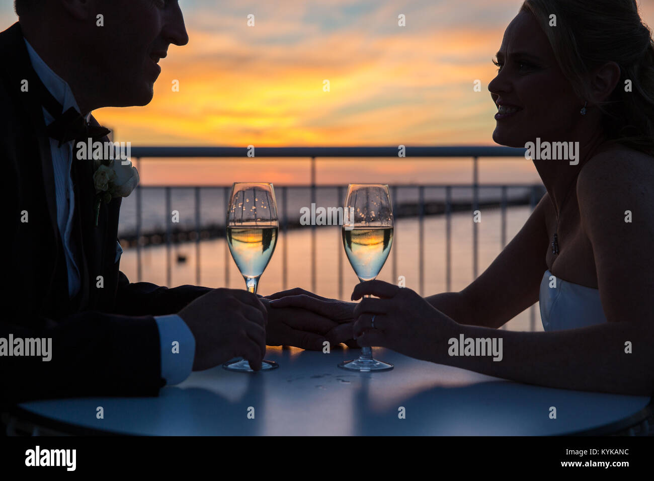 Weingläser auf dem Balkon mit Blick auf die St Kilda Pier bei Sonnenuntergang Stockfoto