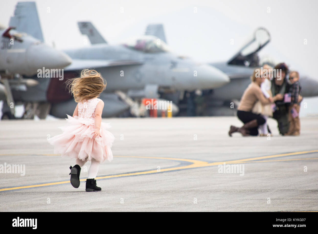 171128-M-auf 157-0009 IWAKUNI, Japan (Nov. 28, 2017) ein junges Mädchen läuft Ihre Familie nach der Ankunft von Strike Fighter Squadron (VFA) 115, VFA-195 und Electronic Attack Squadron (VAQ) 141 bei Marine Corps Air Station (WAB) Iwakuni, Japan zu begrüßen. VFA-115, VFA-195 und VAQ 141 kamen in WAB Iwakuni als Umzug teil Carrier Air Wing (Cvw) 5 von Naval Air Facility (NAF) Atsugi, Japan. Der Umzug von NAF Atsugi zu WAB Iwakuni erfüllt die Final Defense Policy Review Initiative Ziel. Der Umzug ist in Übereinstimmung mit der strategischen Vision der Vereinigten Staaten für das Gleichgewicht in der Ind Stockfoto