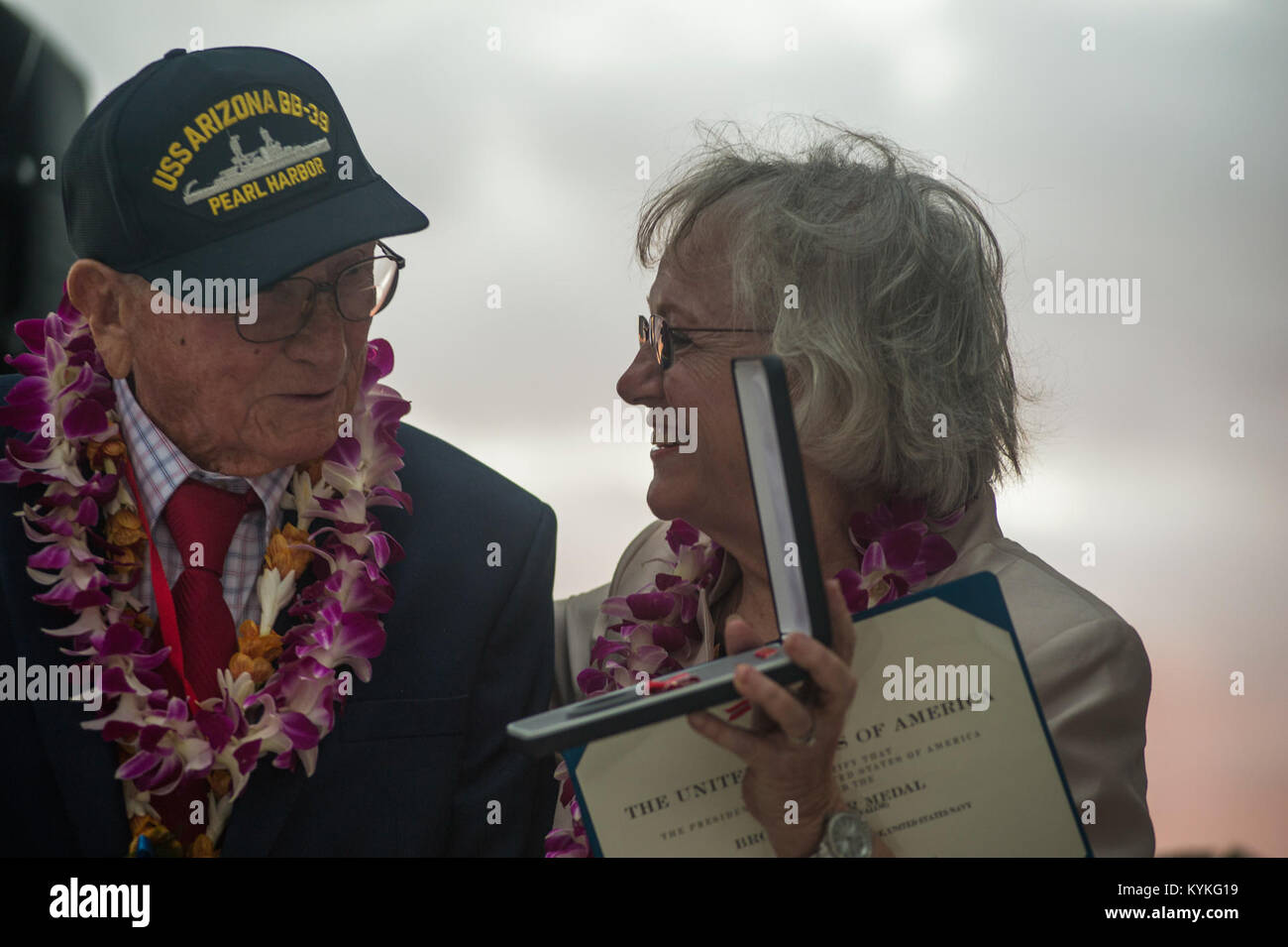 PEARL HARBOR (31. 7, 2017) Chief's Bootsmann Mate Joseph L. George's Tochter, JoeAnn Taylor, zeigt Pearl Harbor überlebenden Donald Stratton ihres Vaters Bronze Star Award auf der USS Arizona Memorial während der 76. Jahrestag der Angriffe auf Pearl Harbor und Oahu am Joint Base Pearl Harbor-Hickam. Der 76. Gedenktag, Co - bewirtet durch das US-Militär, der National Park Service und Hawaii, vorausgesetzt, Veteranen, Angehörige, Service für Mitglieder und die Gemeinschaft die Möglichkeit, die Opfer von denjenigen, Dez. 7, 1941 anwesend waren, sowie in der gesamten pazifischen Thea zu Ehren Stockfoto