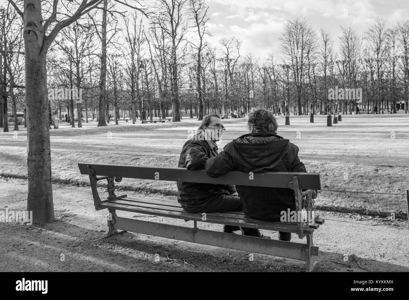 PARIS - Jan. 3, 2014: Zwei Männer auf einer Parkbank im Gespräch an einem Wintertag sitzen. Schwarz und Weiß. Stockfoto