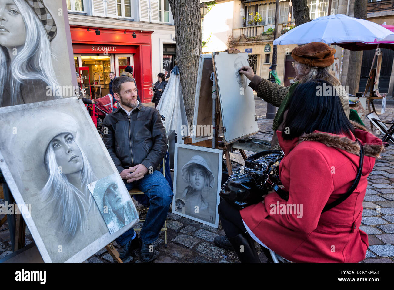Paris, Frankreich. Ein Künstler zeichnet Porträt eines Mannes im Innenhof an der Sacre Coeur Kathedrale, ein traditionelles Souvenir aus der beliebten Paris Website. Stockfoto