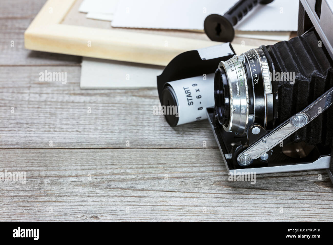 Retro Kamera, Film Roll, Bilderrahmen und alte Bilder auf grau Holz- Hintergrund Stockfoto