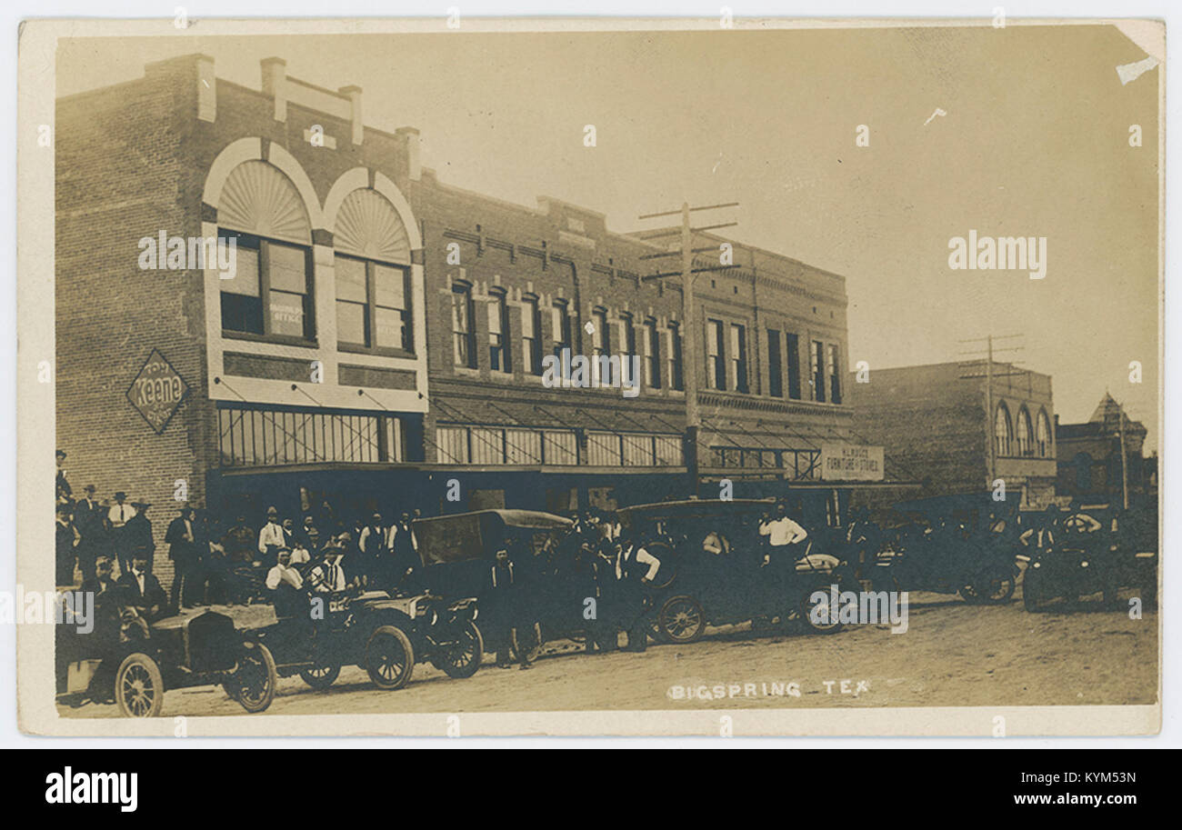 Ein historisches Foto von Oldtimern, die entlang einer Straße geparkt sind, mit Frauen und Männern im Hintergrund. Das Bild zeigt eine Momentaufnahme der amerikanischen Kultur und des Fahrzeugdesigns aus der Mitte des 20. Jahrhunderts. Stockfoto