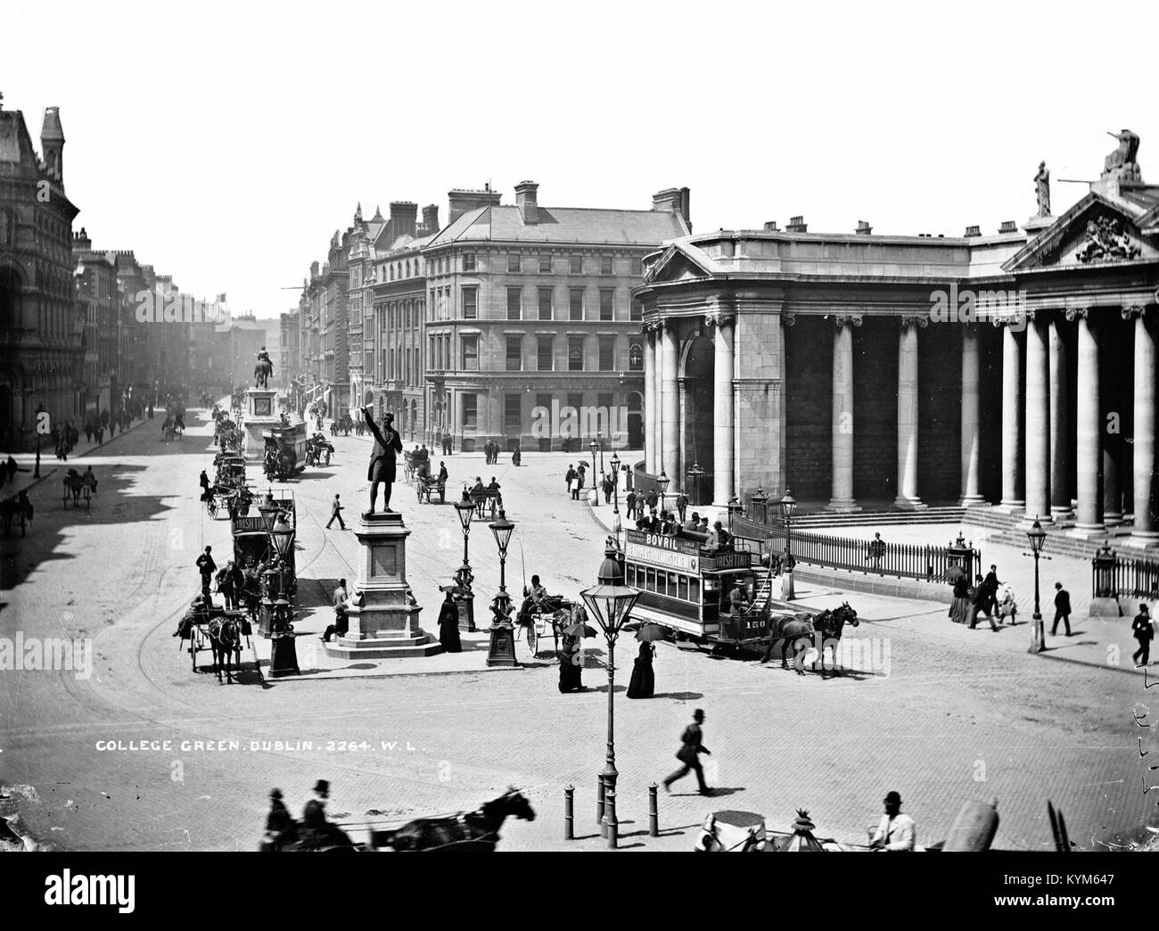 Ein Bild von College Green in Dublin, Irland, aufgenommen in den 1890er Jahren Das Foto zeigt das Gebäude der Bank of Ireland und die Grattan-Statue, Pferdekutschen und Menschen in historischer Kleidung. Das Bild stellt die historische Stadtlandschaft der Stadt während der viktorianischen Ära dar. Stockfoto