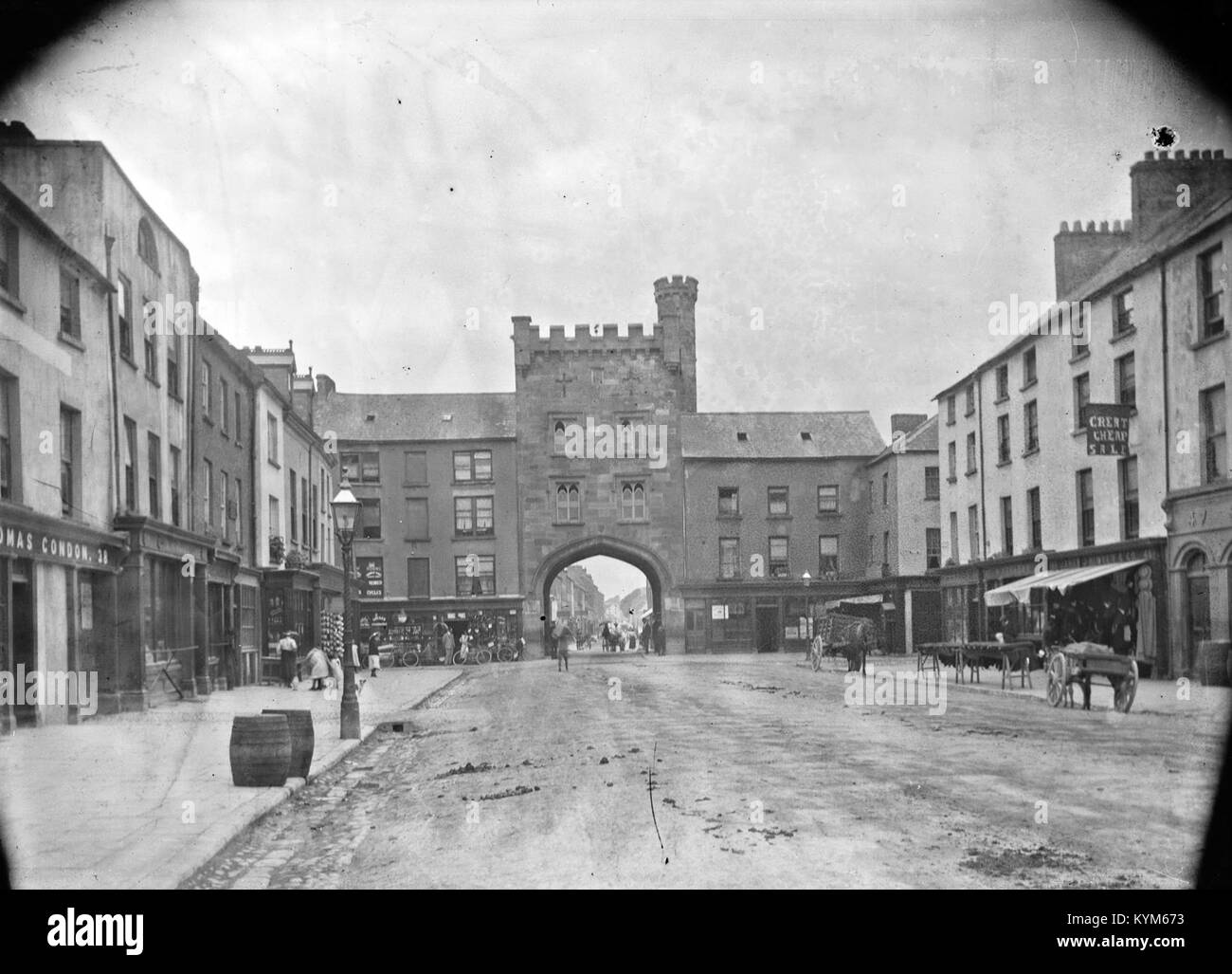 Ein Bild, das ein Dilemma in Clonmel, County Tipperary, zeigt, wo eine historische Burgstruktur und Verkehrshindernisse erfasst werden. Die Aussicht umfasst das Westtor, die Hauptwache und ein Gebäude im Tudor-Revival-Stil mit einer zinnenbefestigten Attika entlang der O'Connell Street, die Teil der Eason Collection ist. Stockfoto