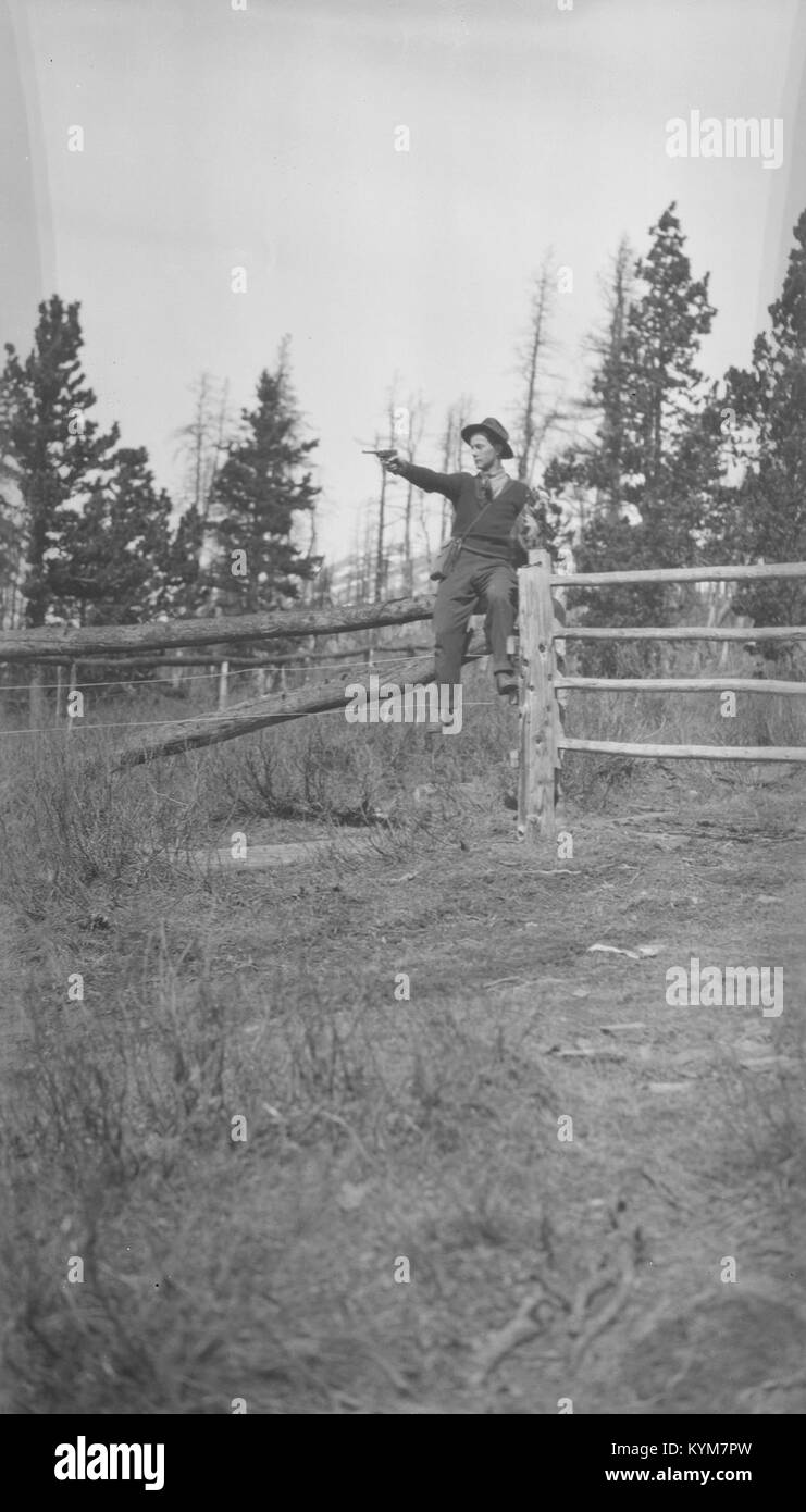 Ein Foto, das Allen Godby in einem Korral zeigt und eine Luger-Pistole hält. Das Bild fängt einen historischen Moment ein, wahrscheinlich aus einer westlichen Szene oder einem Ereignis in der Mitte des 20. Jahrhunderts. Stockfoto