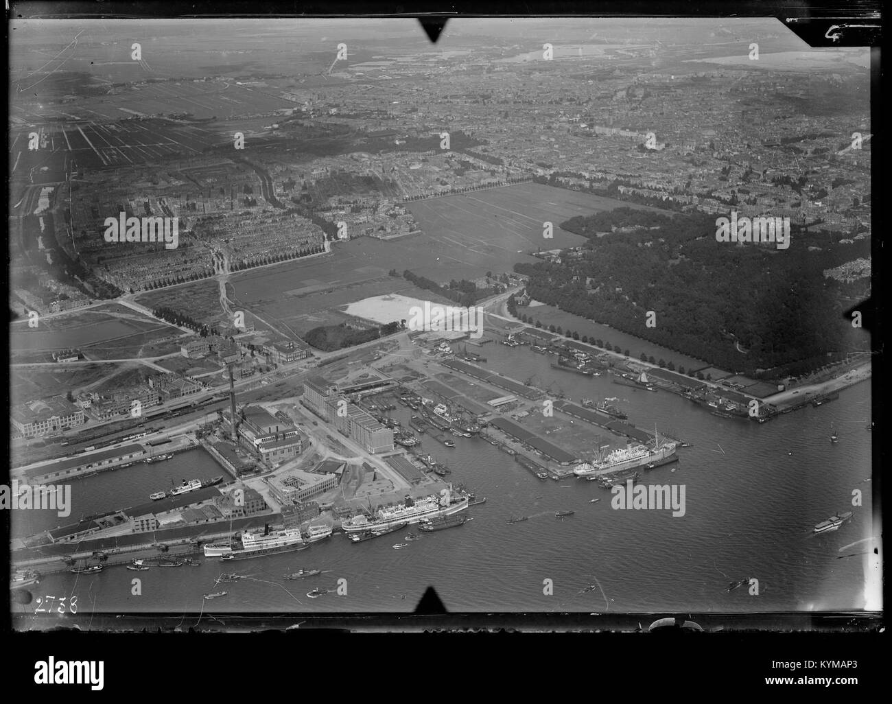 Luftaufnahme von Rotterdam, aufgenommen zwischen 1920 und 1940, die die Entwicklung der niederländischen Stadt während des frühen 20. Jahrhunderts zeigt. Dieses Vintage-Bild zeigt Rotterdams urbane Landschaft während einer Transformationsphase. Stockfoto