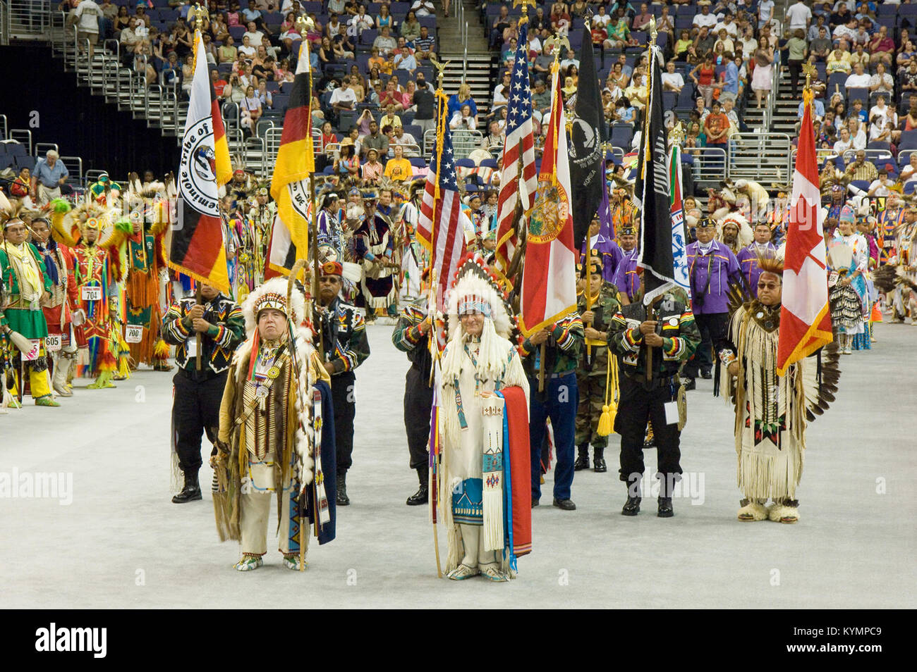 Ein Foto des Powwow 2005 in Kanada, das eine Menge indianischer Ureinwohner in zeremonieller Kleidung mit lebhaften Flaggen und Insignien während eines traditionellen Ereignisses zeigt, das von verschiedenen Stämmen gefeiert wird. Stockfoto