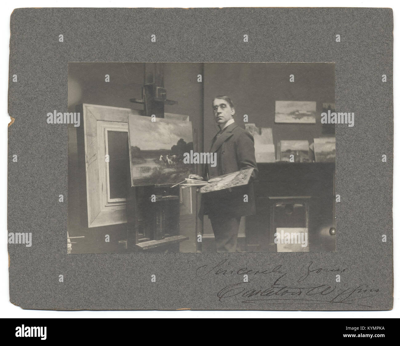 Ein Porträt des impressionistischen Malers Carleton Wiggins aus dem späten 19. Jahrhundert. Das Foto zeigt Wiggins in seinem Atelier mit seinen Werkzeugen und Materialien, die seine künstlerische Umgebung darstellen. Stockfoto