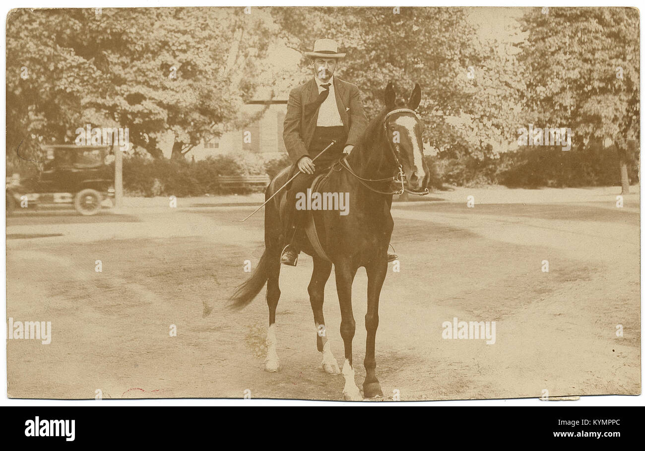 Ein Schwarzweiß-Foto von Theophile Schneider, auf dem er auf einem Pferd sitzt, einen Hut trägt und einen Stock hält. Dieses Bild ist Teil der Sammlung Archives of American Art, die historische Figuren im Reitsport dokumentiert. Stockfoto