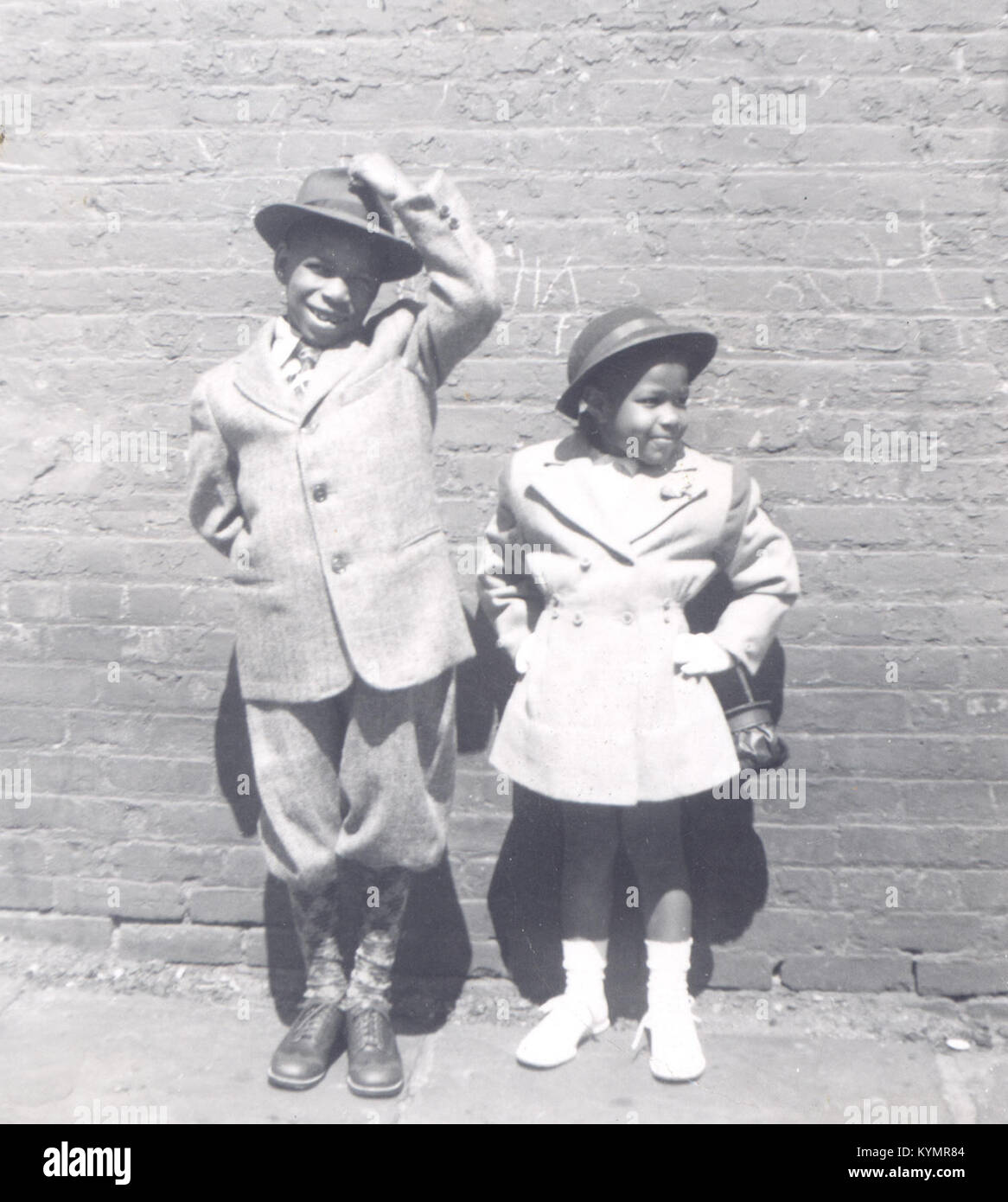 Dieses Schwarzweiß-Foto aus dem Jahr 1946 zeigt eine lächelnde afroamerikanische Familie, wahrscheinlich aus der Sammlung der Familie Harris im Anacostia Community Museum. Das Foto fängt den Charme eines Sonntagsmoments der Familie ein und zeigt Kinder in Hüten und stilvoller Kleidung. Stockfoto